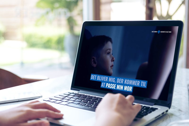 Mockup image of hand using laptop with blank white screen on vintage wooden table in cafe